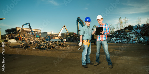 Photos engineers having a discussion in scrapyard