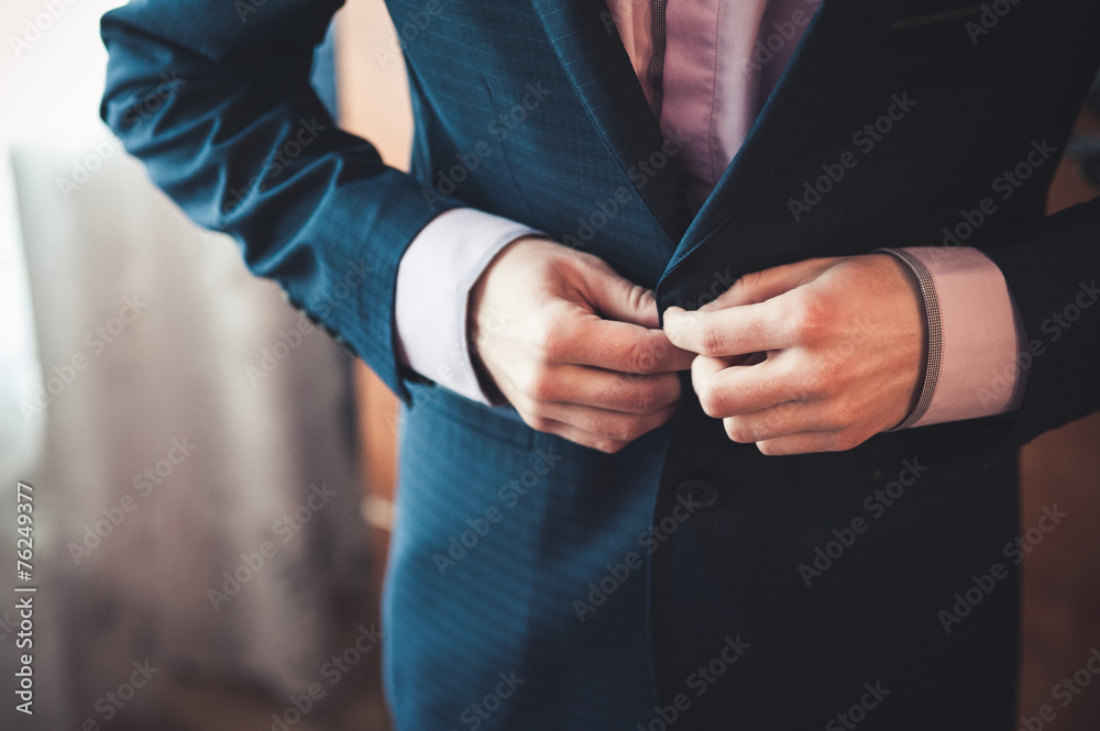 men fastens his black suit