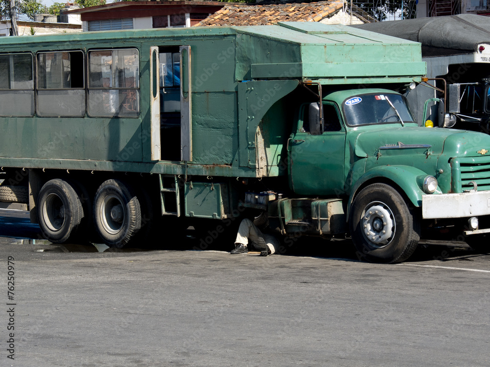 Chauffeur réparant son camion à Cuba.