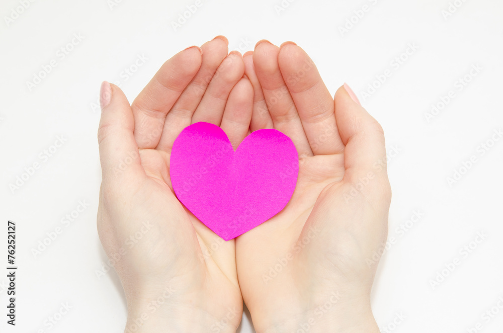 Women's hands holding a pink heart Women's hands holding a pink heart