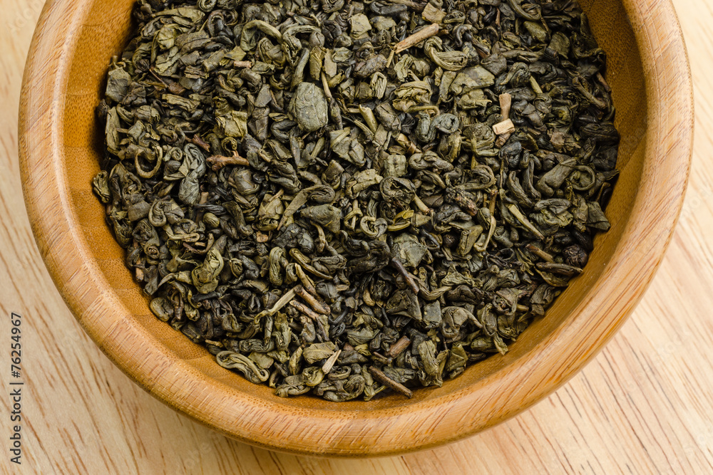 green tea, dried leaves, on wooden background