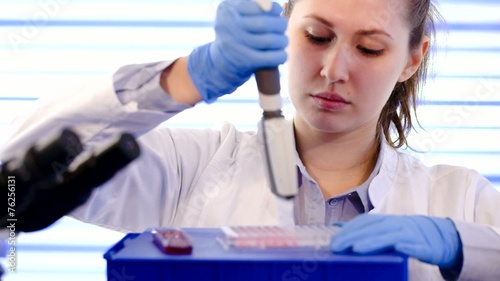 womanl with multi pipette in the laboratory of microbiology