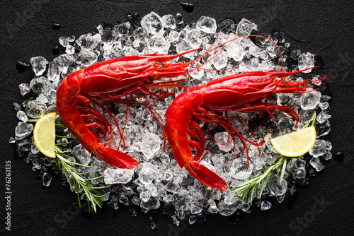 Fresh big red shrimp on ice on a black stone table top view