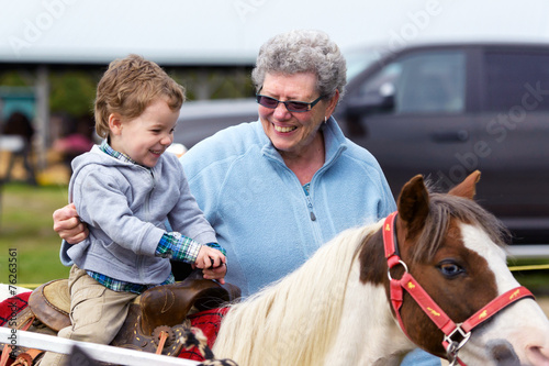 Boy Rides a Pony at a Fair photo