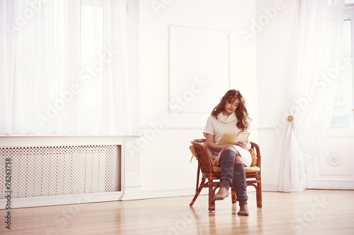 Woman reading a book in chair