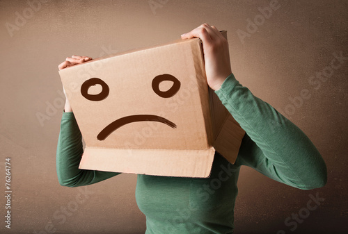 Young girl gesturing with brown cardboard box on her head with s photo