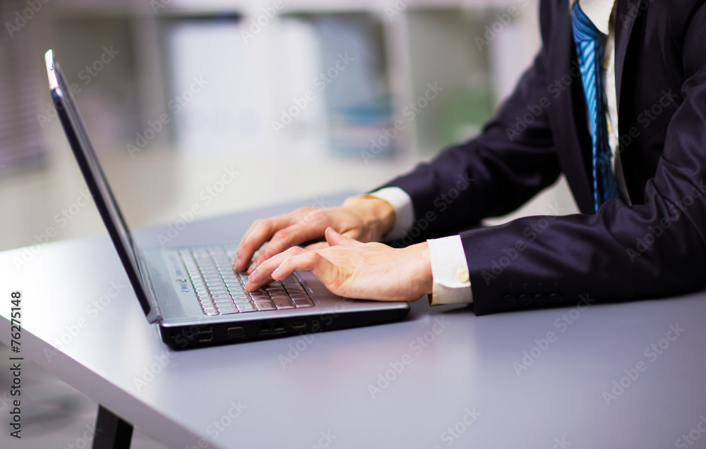 Person Typing on a modern laptop in an office Person Typing on a modern laptop in an office