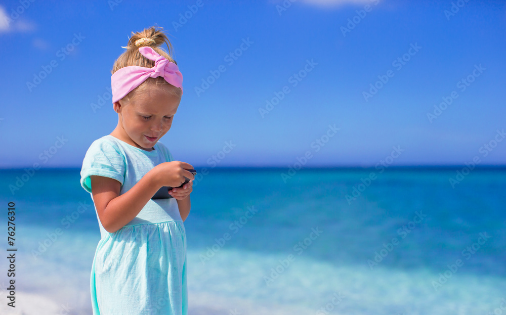 Adorable little girl having fun during beach vacation