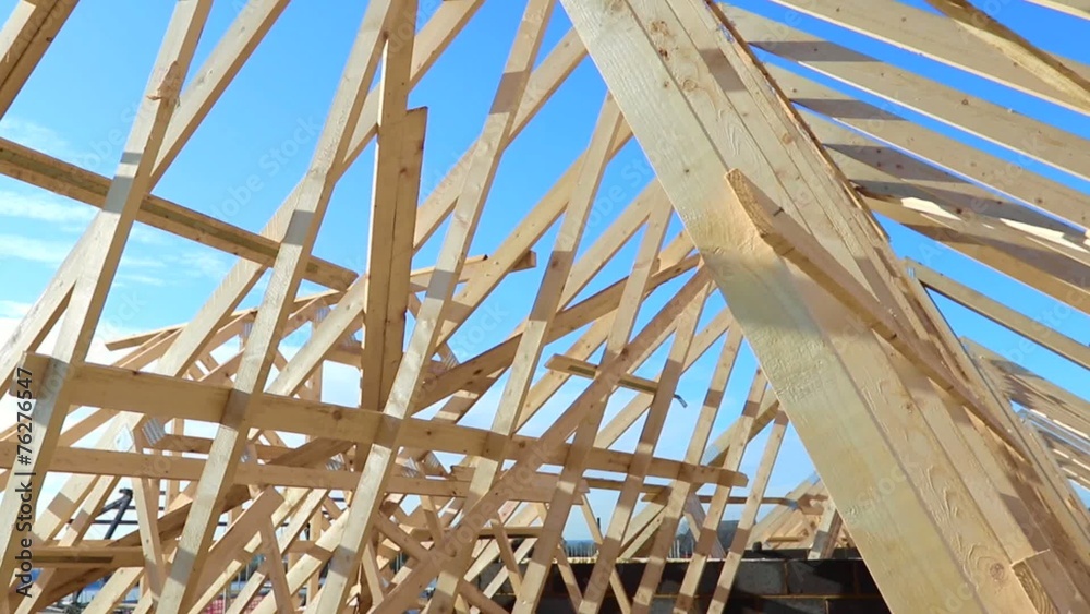 New residential construction home framing against a blue sky New residential construction home framing against a blue sky