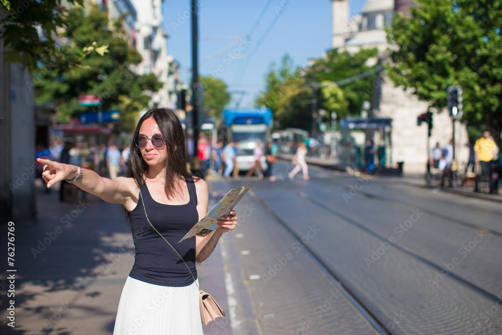 Fototapeta premium Young beautiful traveling woman with map in the city