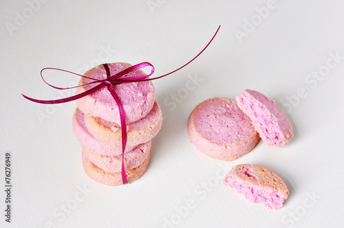 Raspberry pink cookies with ribbon on white background