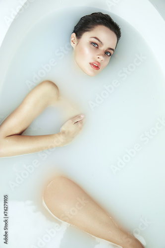 Beautiful sexy woman in bath with milk spa cosmetic body