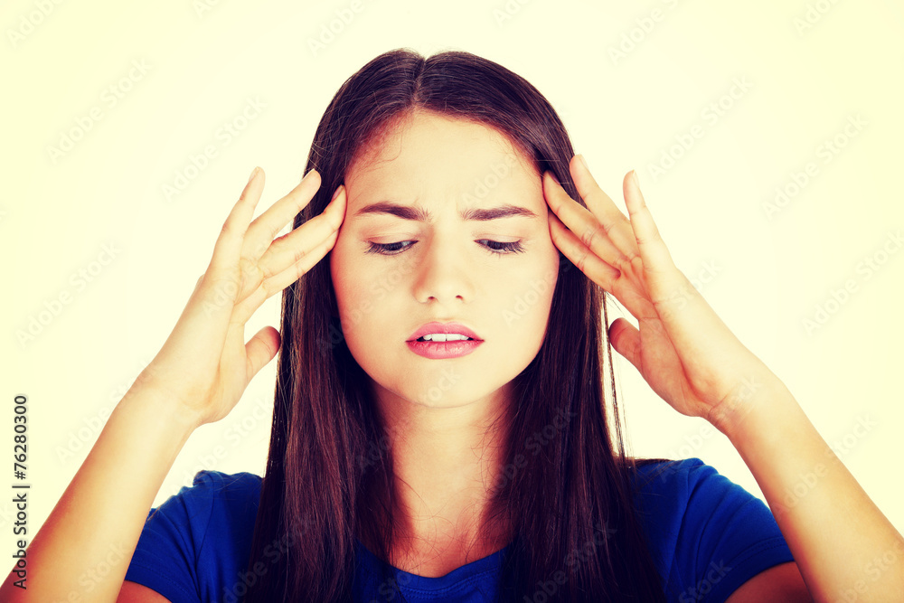 Obraz premium Young casual woman is touching her temples.