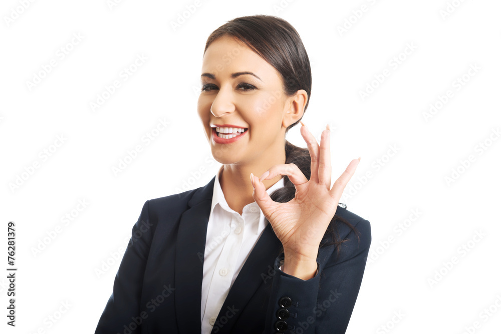 Businesswoman showing ok sign, looking at the camera Businesswoman showing ok sign, looking at the camera