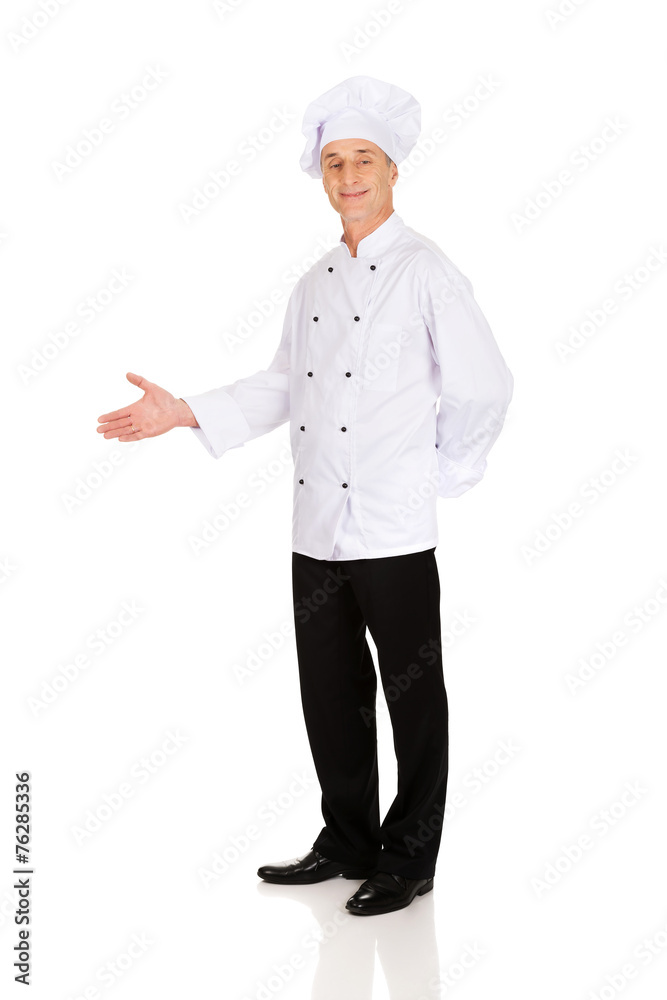 Happy mature chef with welcome gesture Happy mature chef with welcome gesture