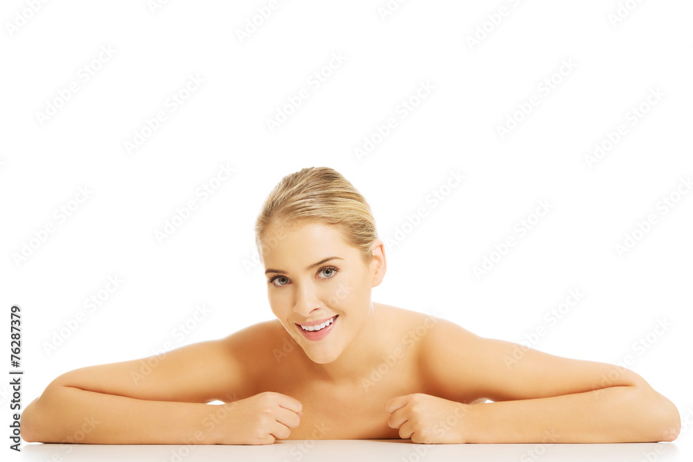 Portrait of happy nude woman sitting at the desk making fists Portrait of happy nude woman sitting at the desk making fists