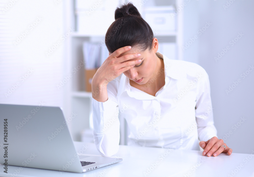 Stressed businesswoman sitting at desk in the office Stressed businesswoman sitting at desk in the office