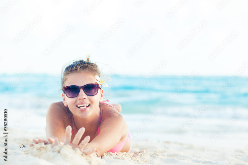 young woman in bikini and sunglasses on tropical beach