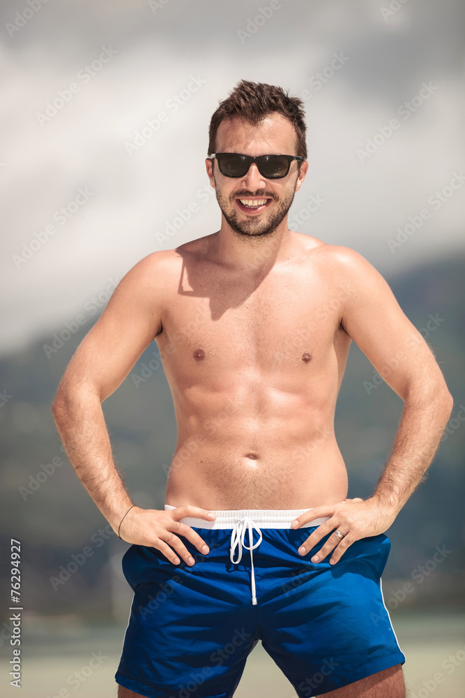 Obraz premium Sexy young man posing at the seaside
