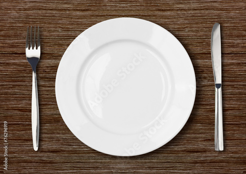 white empty dinner plate setting on dark wooden table