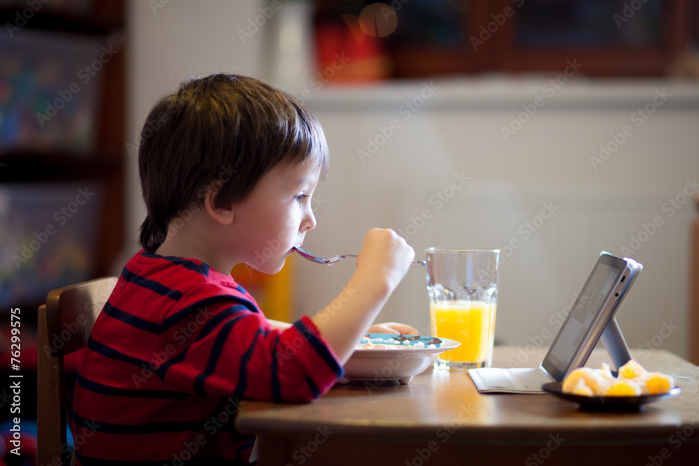 Adorable boy, eating his supper, while watching movie Adorable boy, eating his supper, while watching movie