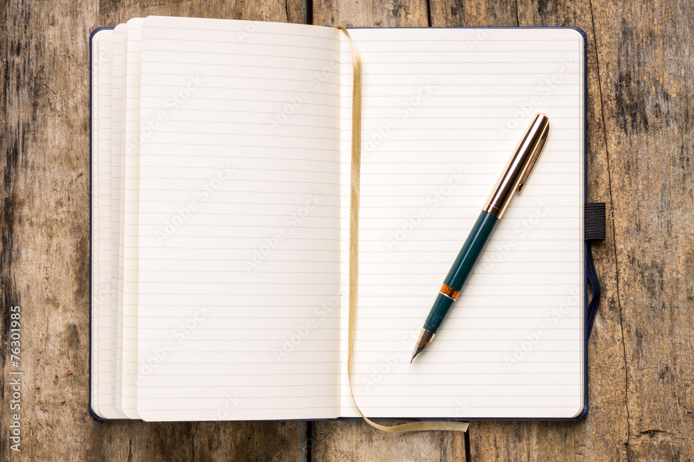 Opened empty notebook on wooden table Opened empty notebook on wooden table