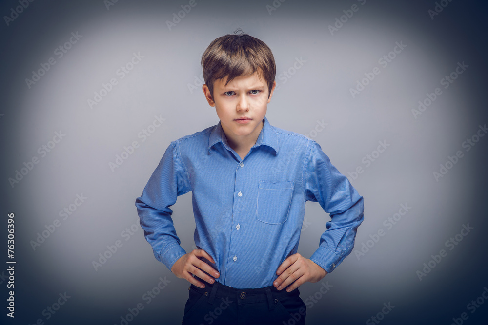 Fototapeta premium teenager boy angry hands on hips gray background cross proc