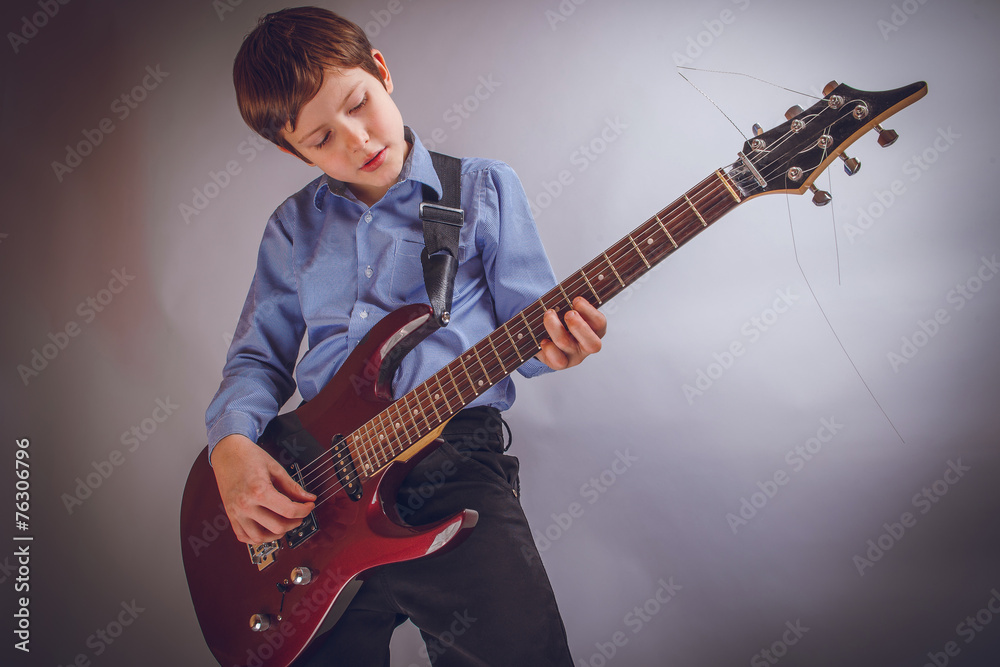 teenager boy of 10 years European appearance rejoices plays g
