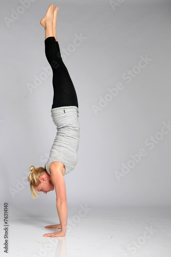 Fototapet blonde Frau macht handstand