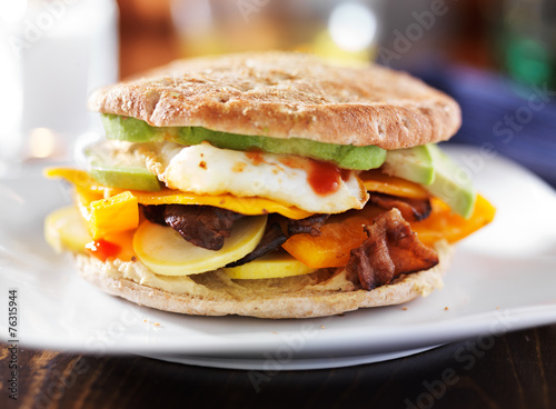 breakfast sandwich with egg, bacon, avocado and vegetables