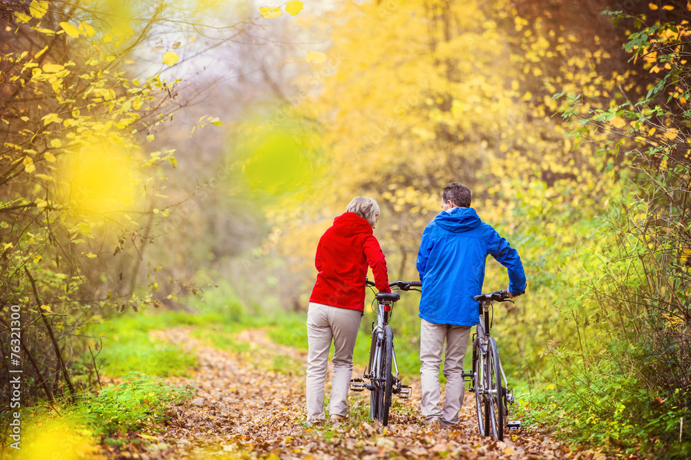 Active seniors walking with bike Active seniors walking with bike