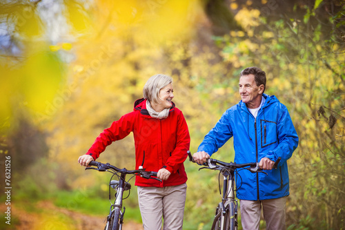 Active seniors walking with bike