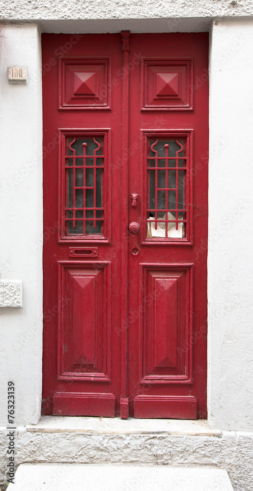 Obraz premium Old red wooden door with window and grid