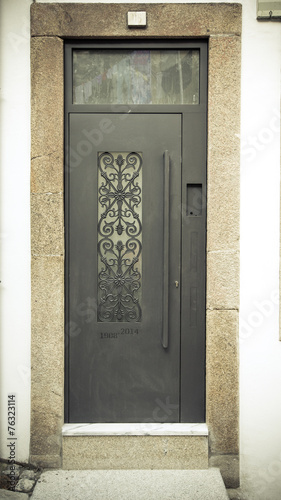 Metal door with patterns on the stone wall. Toned photo