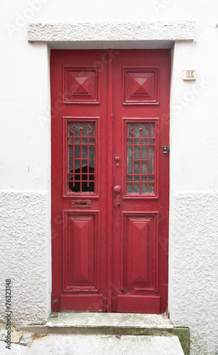 Old red wooden door with window and grid © strannik_fox