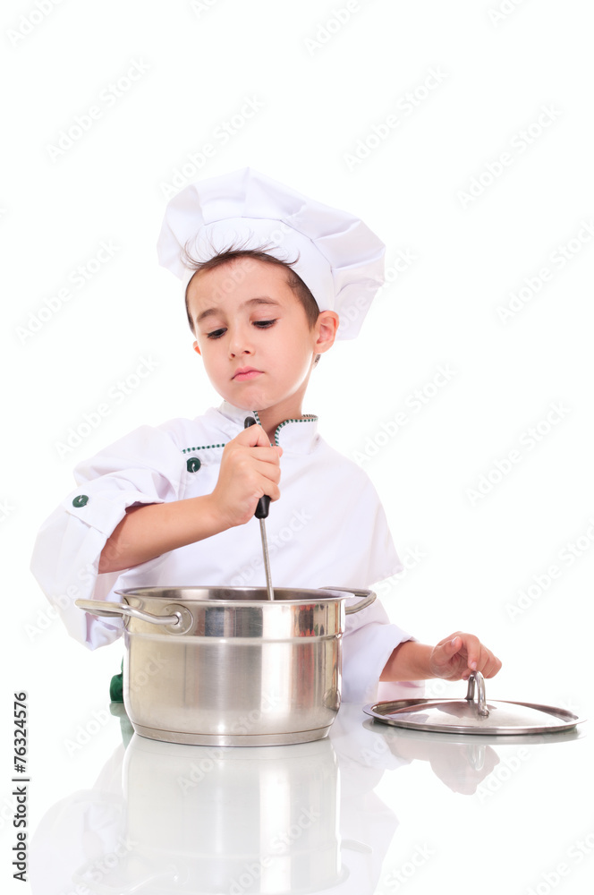 Little boy chef with ladle stiring in the pot Little boy chef with ladle stiring in the pot