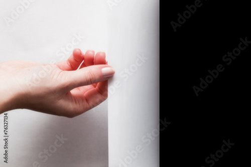 Canvas Print Hand pulling edge of paper to uncover, reveal something
