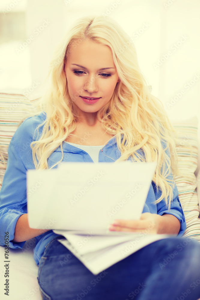 smiling young woman with papers at home