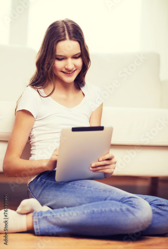 smiling teenage girl with tablet pc at home © Syda Productions