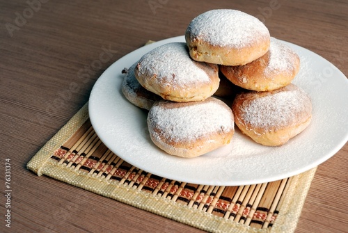 Obraz na płótnie Bun with powdered sugar on a wooden table w salonie