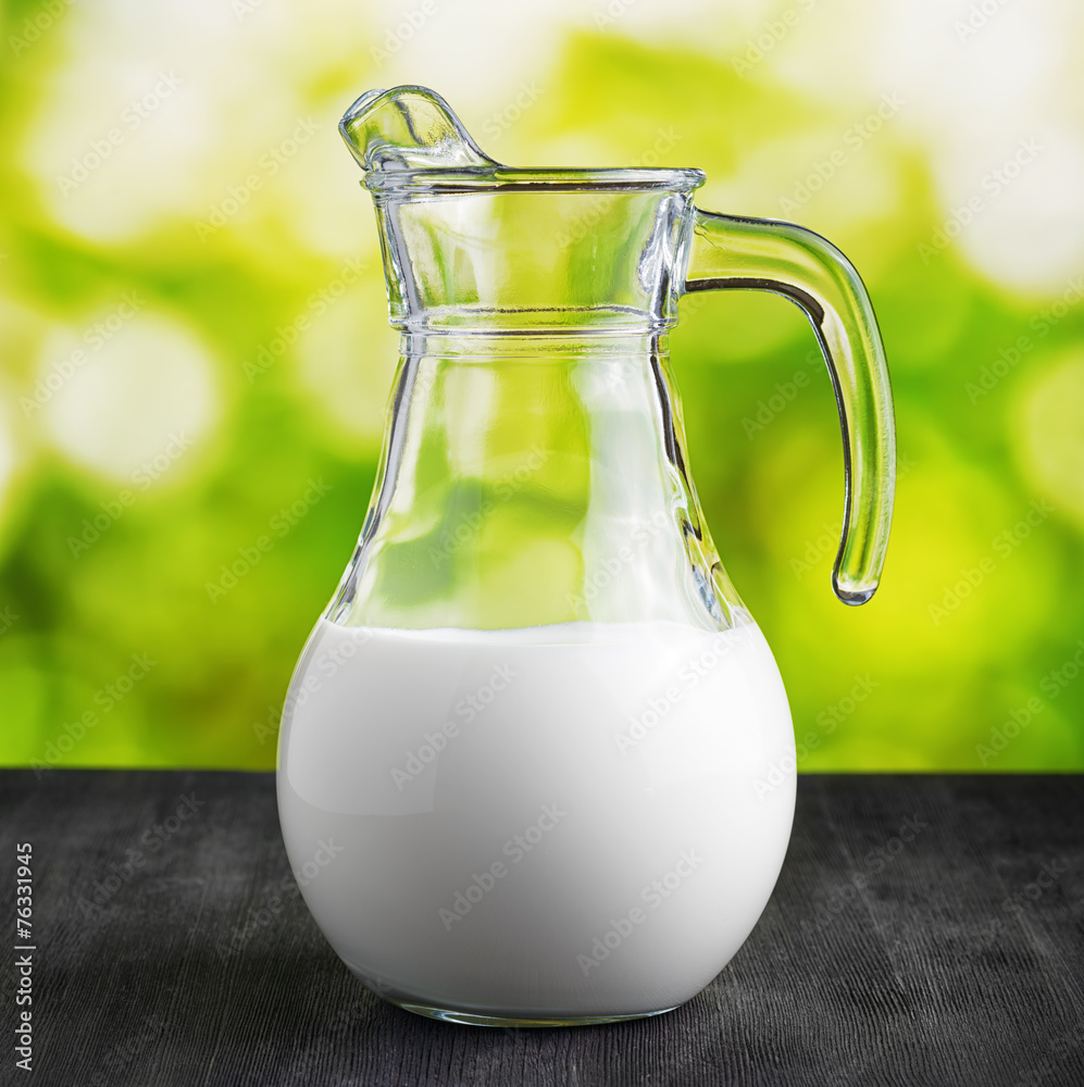 Jug of milk on nature background. Half full pitcher Jug of milk on nature background. Half full pitcher