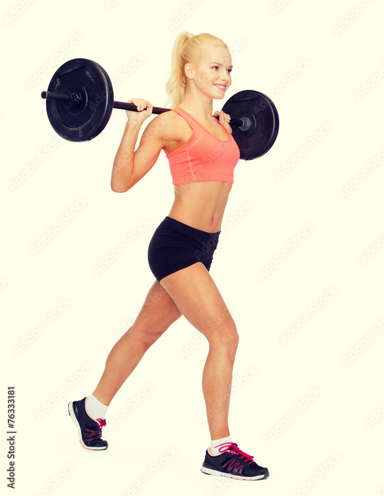 Obraz premium smiling sporty woman exercising with barbell