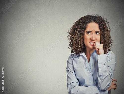 nervous looking woman biting her fingernails craving something