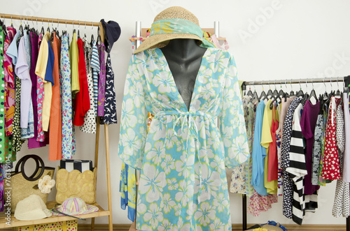Wardrobe with summer clothes nicely arranged and a beach outfit
