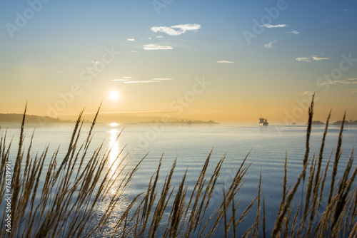 Canvas Print Cargo ship at sunset in the sea