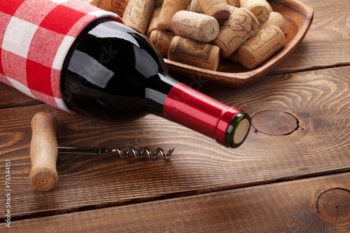 Red wine bottle, bowl with corks and corkscrew