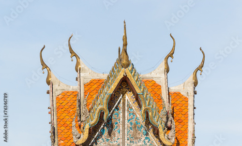 Old tympanum and orange tile roof of local Thai temple