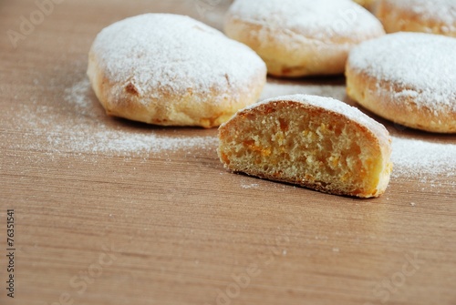 Obraz na płótnie Bun with powdered sugar on a wooden table w salonie