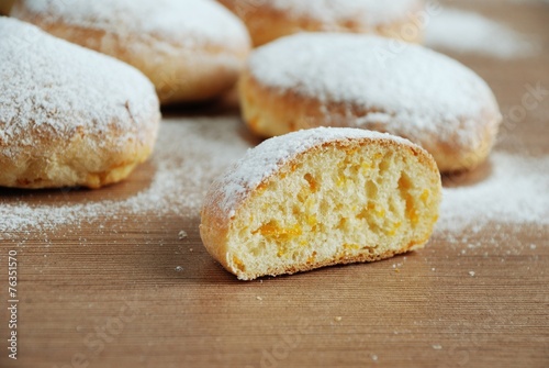 Obraz na płótnie Bun with powdered sugar on a wooden table w salonie