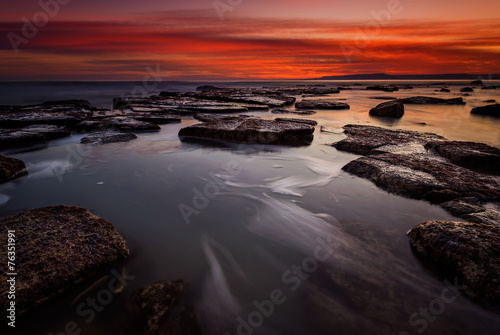Rocky beach long exposure seascape after sunset